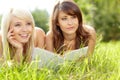 Two young beautiful smiling women reading book Royalty Free Stock Photo
