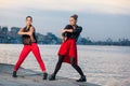 Two young beautiful twin sisters are dancing waacking dance in the city background near river. Royalty Free Stock Photo