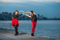 Two young beautiful twin sisters are dancing waacking dance in the city background near river. Royalty Free Stock Photo