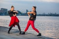 Two young beautiful twin sisters are dancing waacking dance in the city background near river. Royalty Free Stock Photo