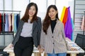 Two young and beautiful woman designers and fashion shop owners standing together and looking at camera with smile faces. Royalty Free Stock Photo