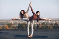 Two beautiful women doing yoga asana virabhadrasana on the roof Royalty Free Stock Photo