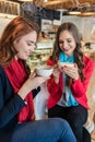 Two young and beautiful women drinking together hot chocolate