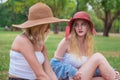 Two young beautiful women talking and chatting in the park