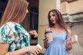 Two young beautiful women talking drinking coffee. Girls having fun in city. Best friends chat outdoors Royalty Free Stock Photo