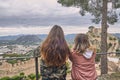 Two young blond-haired and brown-haired teenage girls are observing the landscape inside Xativa castle in Valencia, Spain