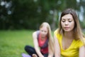 Two young blonde women performs training for flexibility in the park