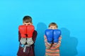 Two young boxers are fighting in boxing gloves in the studio on a blue background