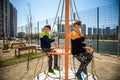 Two young boy active little child playing climbing at spring metal playground his hand to exercise at outdoor. Warm sunny day. Royalty Free Stock Photo