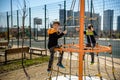 Two young boy active little child playing climbing at spring metal playground his hand to exercise at outdoor. Warm sunny day. Royalty Free Stock Photo