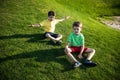 Two Young boy sitting on the grass. Kid are best friends brothers relaxation on nature enjoy warm summer day Royalty Free Stock Photo