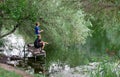 Two young boys fishing on a lake in a summer day. Kids are playing. Friendship.