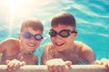 Two young boys holding edge of swimming pool Royalty Free Stock Photo