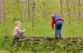 Two young boys playing on a rustic fence