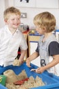 Two Young Boys Playing Together in Sandpit Royalty Free Stock Photo