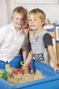 Two Young Boys Playing Together in Sandpit