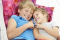 Two Young Boys Relaxing In Garden Hammock Together