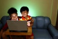 Two Young boys using a laptop computer and smiling Royalty Free Stock Photo