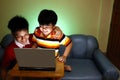 Two Young boys using a laptop computer and smiling Royalty Free Stock Photo