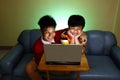 Two Young boys using a laptop computer and smiling Royalty Free Stock Photo