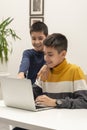 Two young boys  using a laptop  for playing games in the room Royalty Free Stock Photo