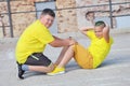 two young boys in yellow T-shirts are training. Training of abdominal muscles