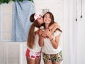Two young brunette girls, wearing colorful bright pajamas, having fun in beach house in tropical resort. Sisters enjoying vacation Royalty Free Stock Photo