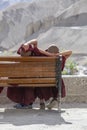 Two young Buddhist monk resting on a bench on the street next to the monastery Lamayuru in Ladakh, North India