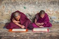 Two Himalayan Bhutanese young novice monks sitting on floor and chanting , Bhutan