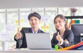 Two young business colleagues showing thumbs up and looking at camera, Smiling business people in modern office Royalty Free Stock Photo