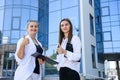 Two young business ladies posing outside office building. Women and business Royalty Free Stock Photo