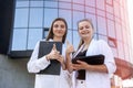 Two young business ladies posing outside office building. Women and business Royalty Free Stock Photo