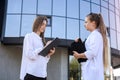 Two young business ladies posing outside office building. Women and business Royalty Free Stock Photo