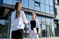 Two young business ladies posing outside office building. Women and business Royalty Free Stock Photo