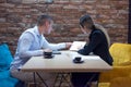 Two young business people brainstorming and discussing business plan on meeting at sunny bright office interior Royalty Free Stock Photo