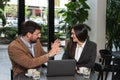 Two young business people having a successful meeting at restaurant. Businessman and businesswoman sitting in cafeteria working Royalty Free Stock Photo