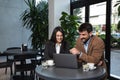 Two young business people having a successful meeting at restaurant. Businessman and businesswoman sitting in cafeteria working Royalty Free Stock Photo