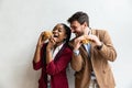 Two young business people or smart casual white man and African American woman holding eating fat tasty American hamburger burger Royalty Free Stock Photo