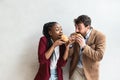 Two young business people or smart casual white man and African American woman holding eating fat tasty American hamburger burger Royalty Free Stock Photo