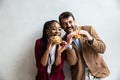 Two young business people or smart casual white man and African American woman holding eating fat tasty American hamburger burger Royalty Free Stock Photo