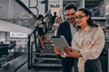 Two young business people stand in the office and look at a digital tablet. Teamwork