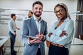 Two young business people are standing together in the office and are talking to each other. Business concept Royalty Free Stock Photo