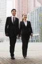 Two young business people walking outdoors, Beijing, China