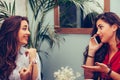 Two young business women arrange a meeting via a mobile phone with their business associates Royalty Free Stock Photo