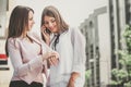 Two young business women arrange a meeting via a mobile phone Royalty Free Stock Photo