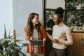 Two young business women with digital tablet standing in the modern office Royalty Free Stock Photo