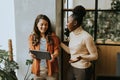 Two young business women with digital tablet standing in the modern office Royalty Free Stock Photo