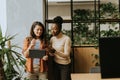 Two young business women with digital tablet standing in the modern office Royalty Free Stock Photo