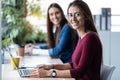 Two young business women friends working together with laptop while talking in the office at home Royalty Free Stock Photo