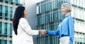 Two young business women shake hands closing a deal in a financial district. Successful women entrepreneurs Royalty Free Stock Photo